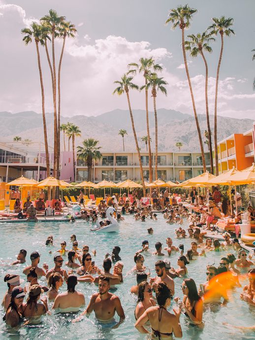 Pool party on a sunny day, palm trees and mountains in background