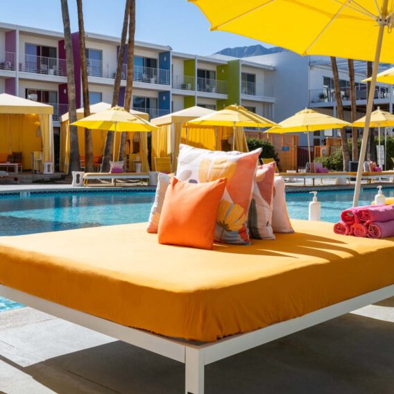 A pile of pillows on a daybed by the pool