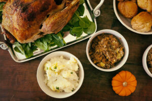 Thanksgiving dinner in Palm Springs: roast turkey, mashed potatoes, stuffing, and rolls on a table.