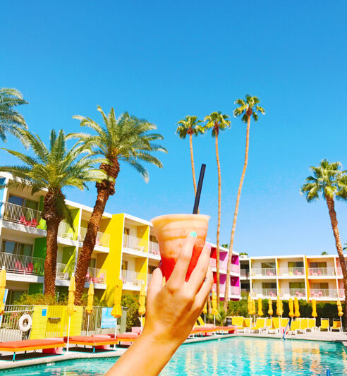 a person holding a smoothie by the pool at Saguaro Palm Springs