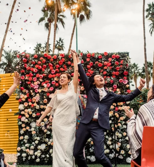 Newlyweds celebrating with flower backdrop in Palm Springs weddings