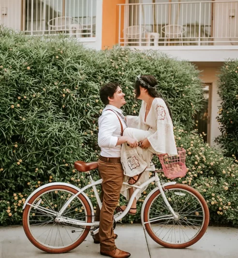 Two people sharing an affectionate moment on a white bicycle.